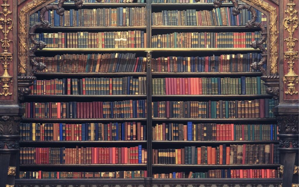 Leatherbound books in an antique bookshelf illustrates Dark Academic Decor