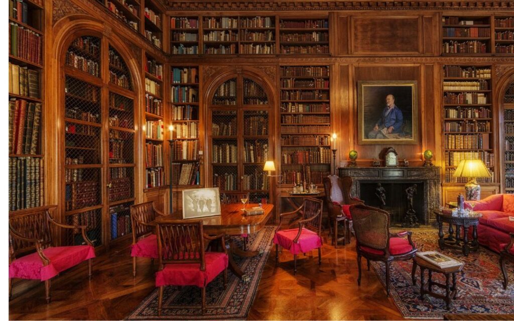 Luxurious estate library with red velvet chairs and leatherbound books oriental carpets illustrates Dark Academic Decor