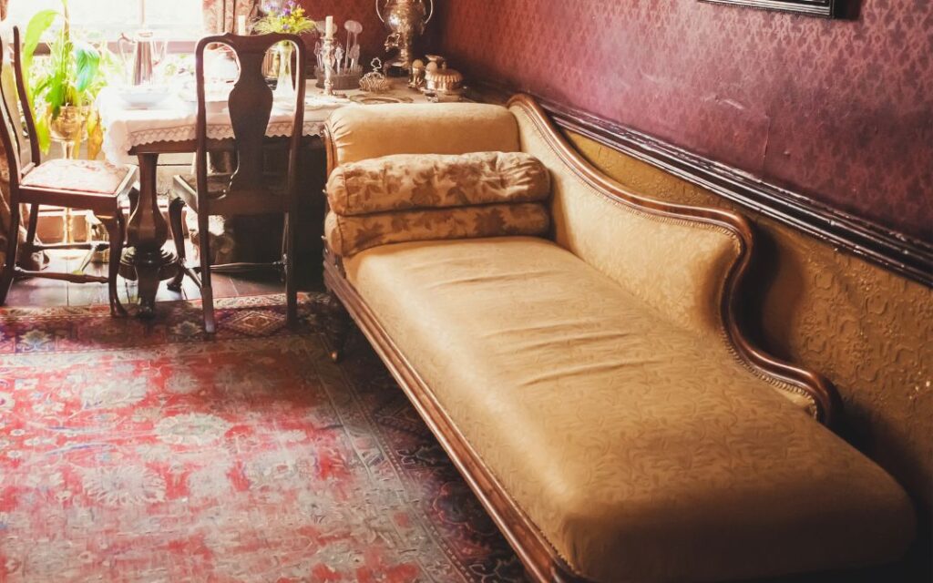 Yellow silk victorian chaise lounge with oriental carpet illustrates Dark Academic Decor