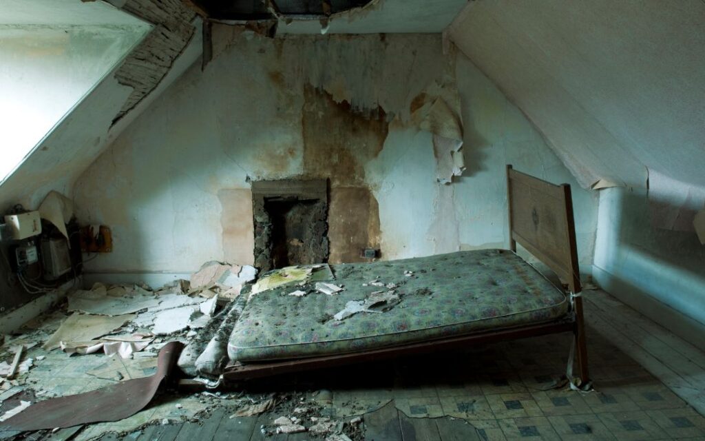 Spooky abandoned attic with fallen apart bed illustrates Dark Academic Decor