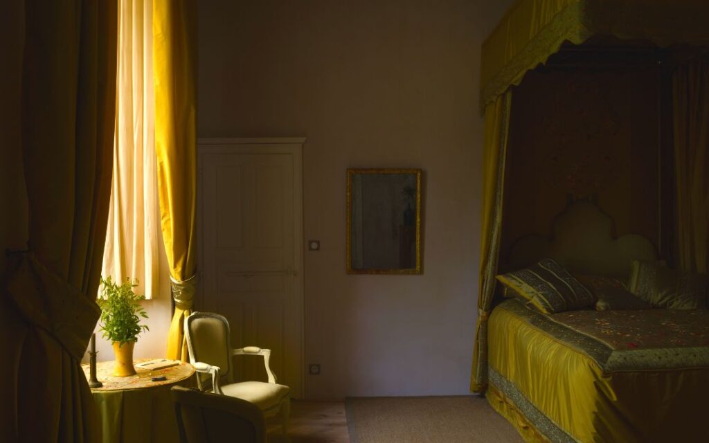 Dark Academic Decor yellow silk bedroom with chair by the window and luxe bed